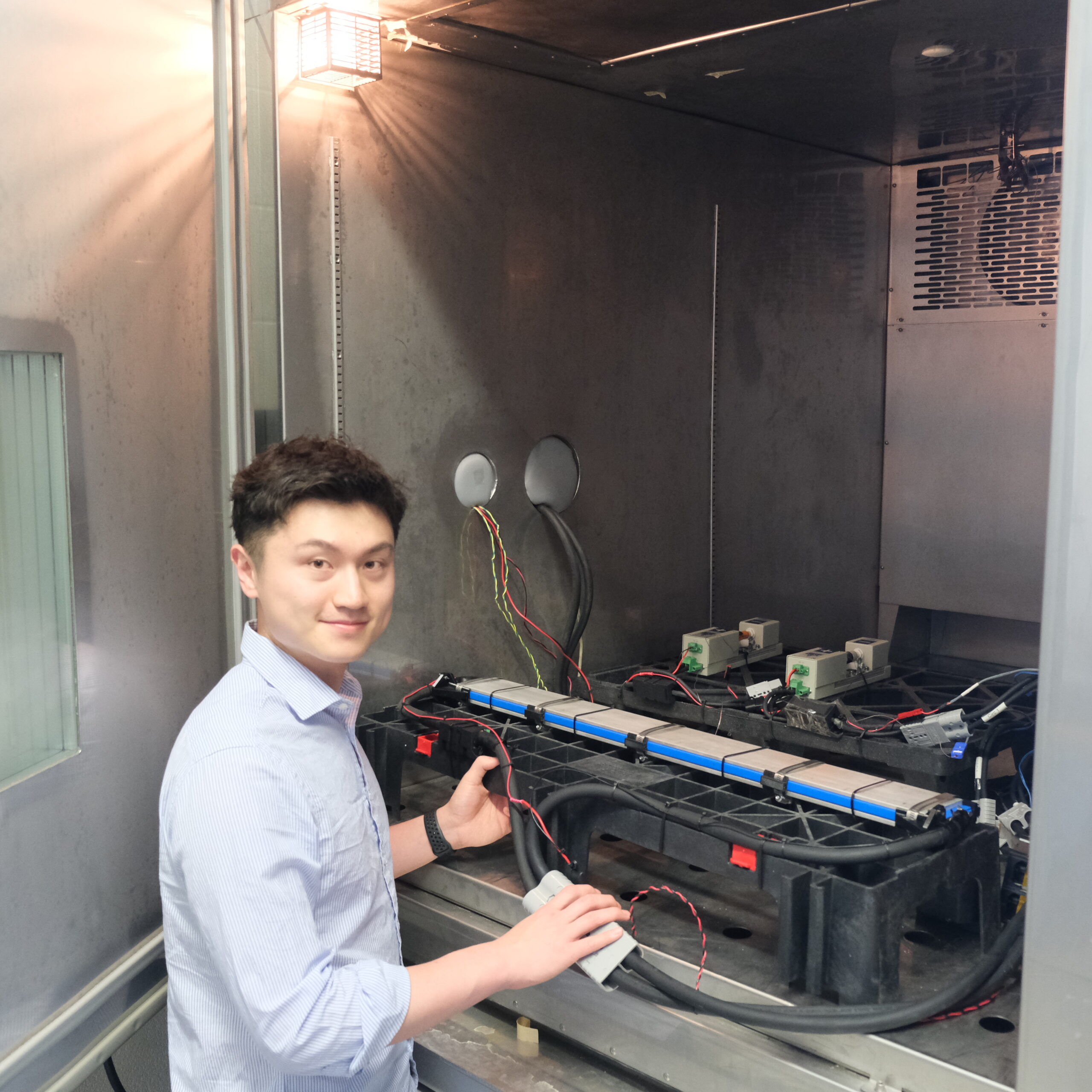 Junran looking at the camera as he sets up his blade cell for testing inside the large thermal chamber.