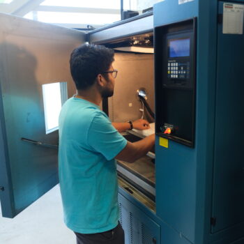 Biswanath in front of the medium chamber which indicates the size. He is setting up the chamber for testing.