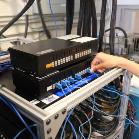 Sobhika securing the thermocouple connections on the temperature module for the 16-channel cycler, with various cables and connectors attached to the module in a laboratory setting.