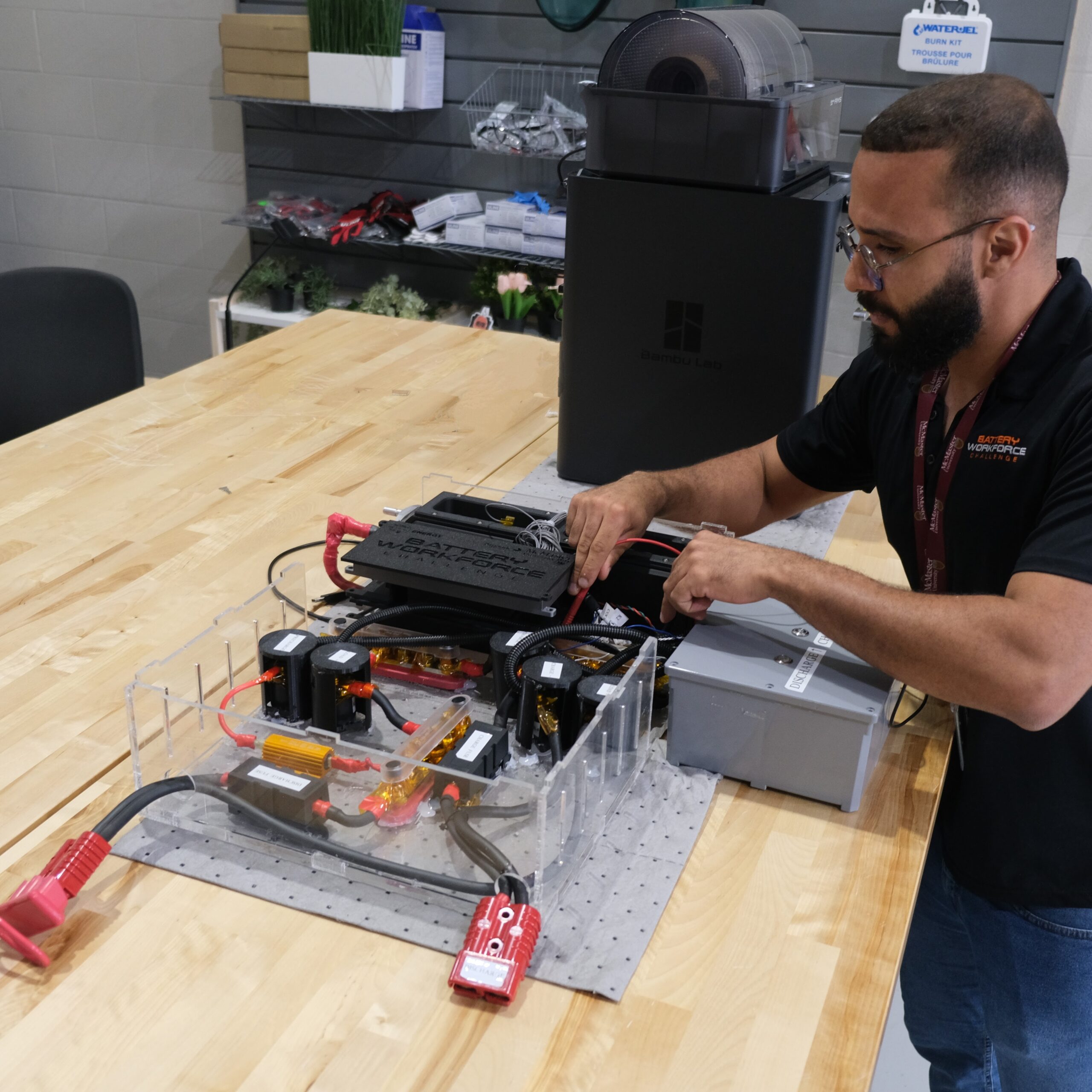 image showing the Project Manager of the Battery Workforce Challenge, Romulo, testing the battery module on a desk.